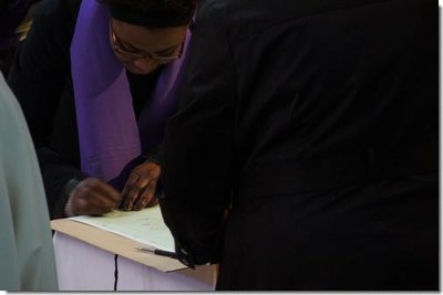 Doté de l'écharpe violette, chaque catéchumène va signer le registre...